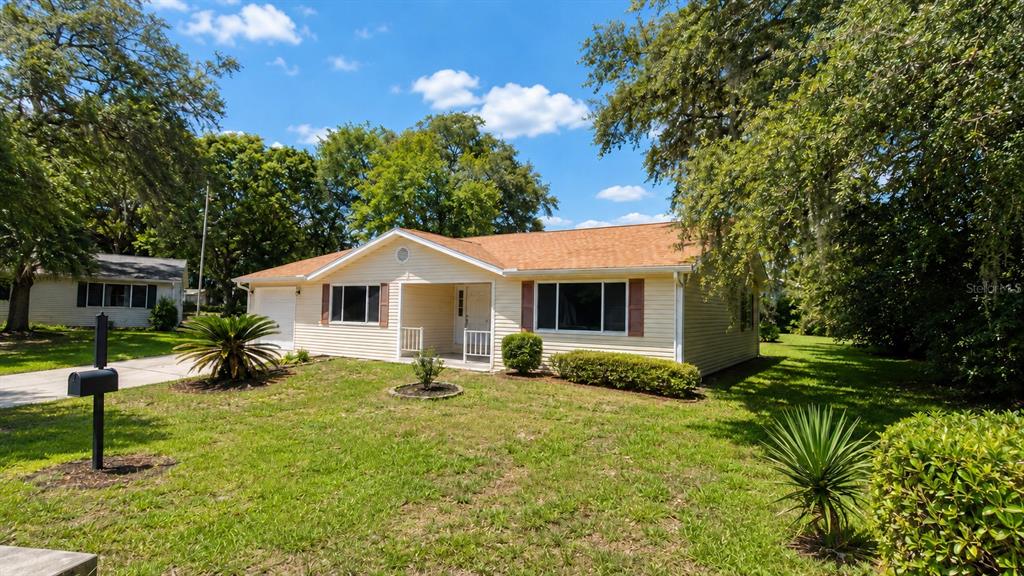 A single-story house with light yellow siding, a brown roof, and a front lawn — 10920 SW 82ND TERRACE, OCALA, FL