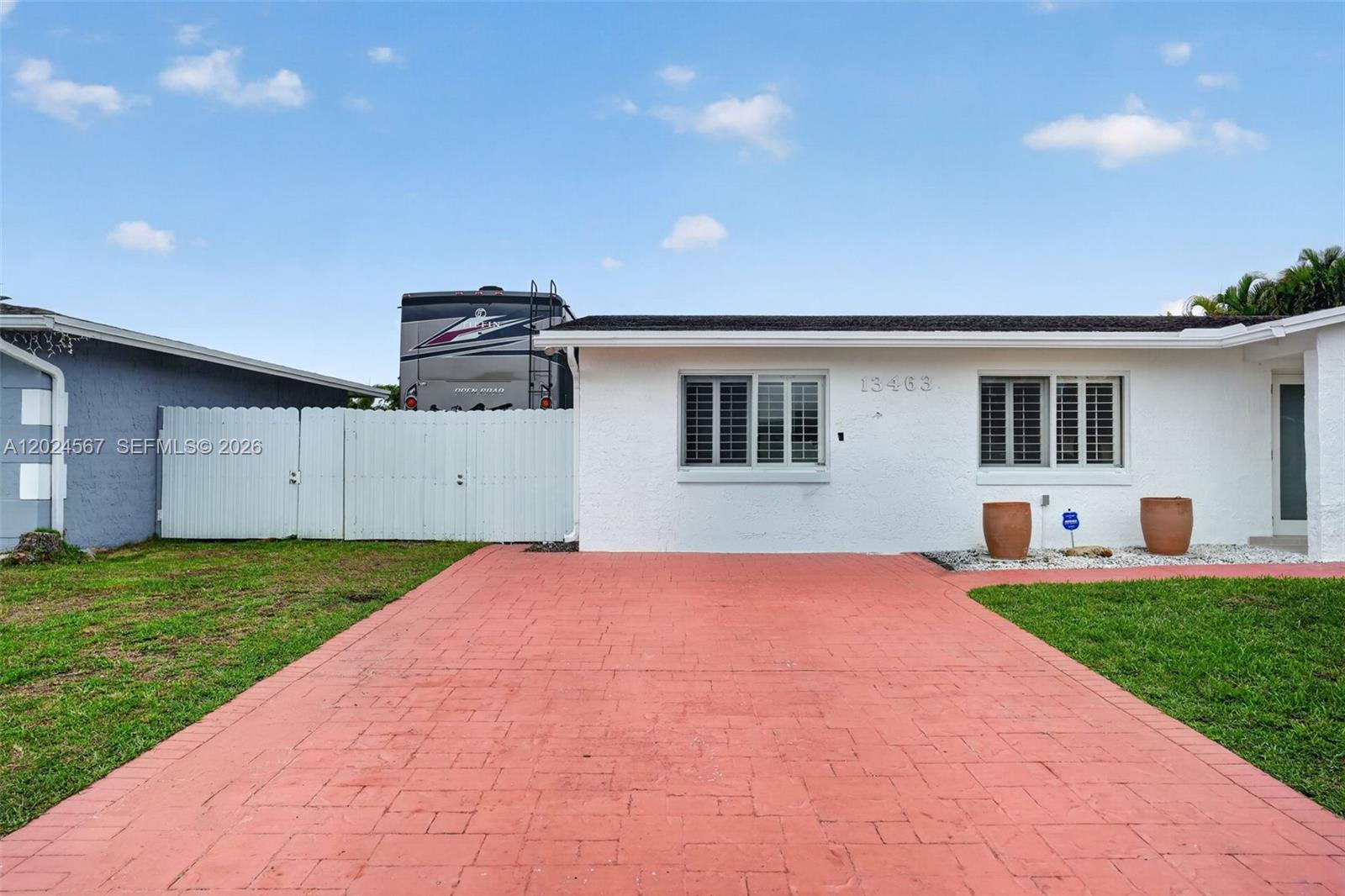 A white single-story house with a red paver driveway and a large RV parked behind — 13463 SW 66th Ter, Miami FL 33183, MIAMI, FL