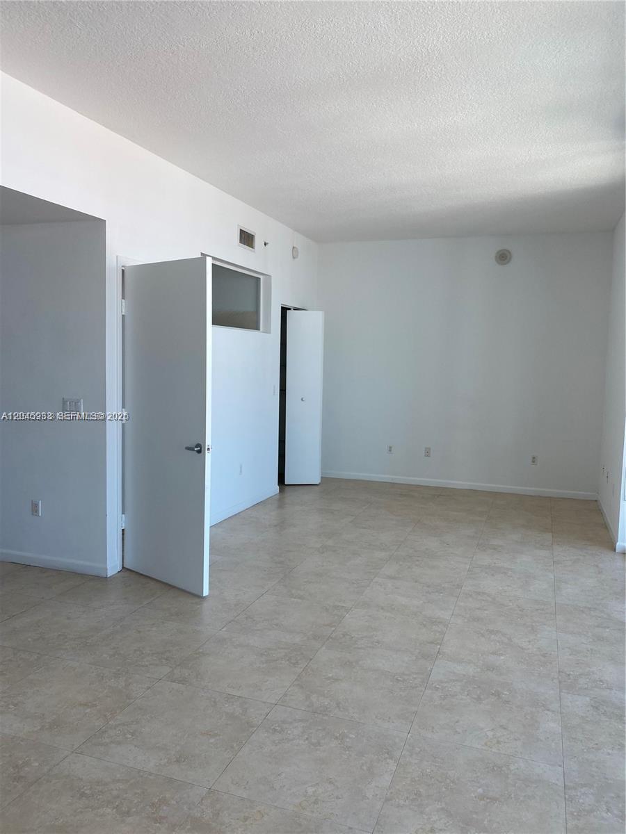 An empty room features white walls, tile flooring, and two open white doors — 350 NE 24th St # 813, Miami FL 33137, MIAMI, FL