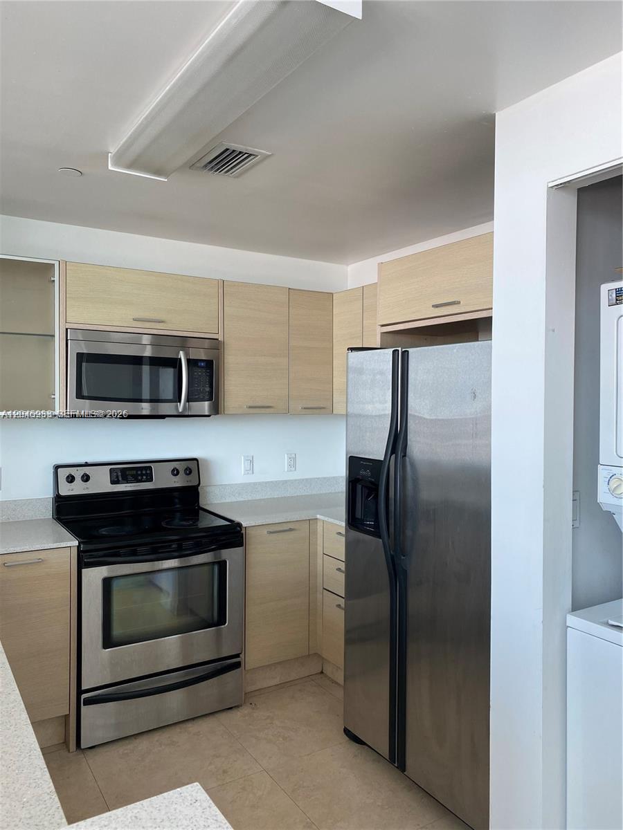 A kitchen features light wood cabinets, stainless steel appliances, and light-colored countertops — 350 NE 24th St # 813, Miami FL 33137, MIAMI, FL