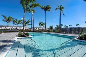 A swimming pool with steps and palm trees under a clear blue sky — 4941 Peacock Way # 5838, Dania Beach FL 33312, DANIA BEACH, FL