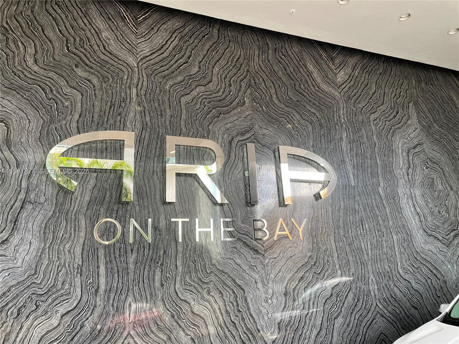 A wall features a large, metallic sign reading "ARIA ON THE BAY" over dark, wavy-patterned marble — 488 NE 18th St # 1000, Miami FL 33132, MIAMI, FL