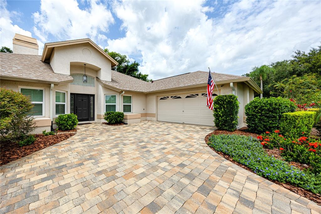 A single-story house with a paved driveway, a two-car garage, and a front entrance — 16706 WINDSOR PARK DRIVE, LUTZ, FL