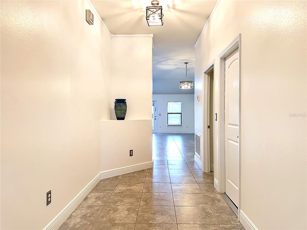 A tiled entryway leads into a hallway with white walls and two light fixtures — 9210 52ND AVENUE E, PALMETTO, FL