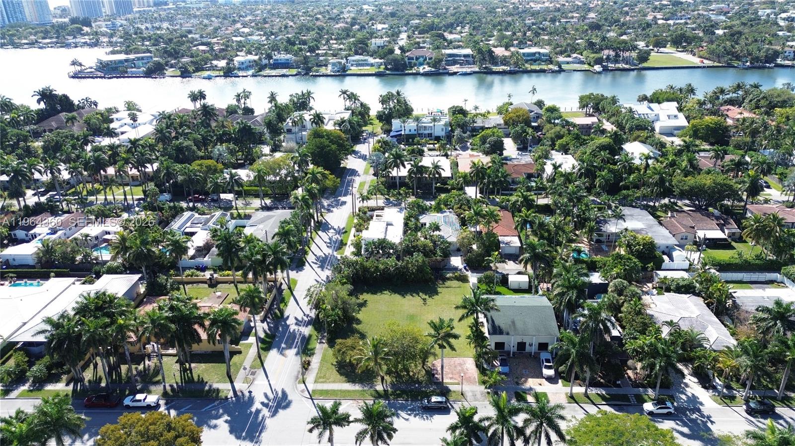 An aerial view shows a residential neighborhood with houses, palm trees, and a waterway — 1000 Harrison St, Hollywood FL 33019, HOLLYWOOD, FL