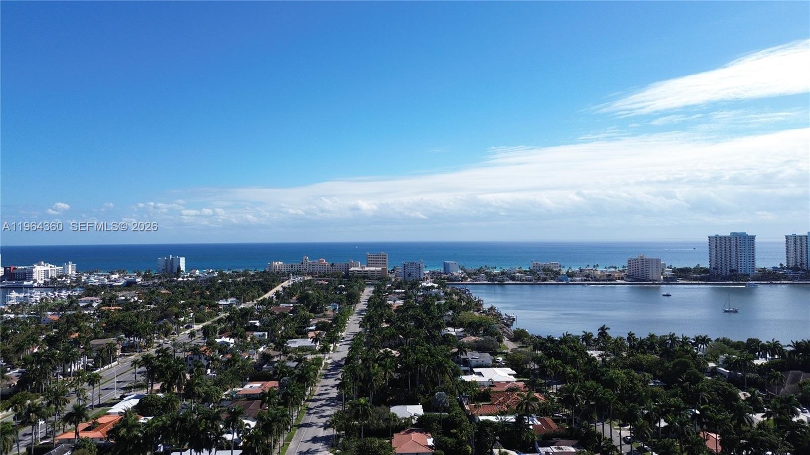 An aerial view shows a coastal neighborhood with palm trees, a waterway, and high-rise buildings — 1000 Harrison St, Hollywood FL 33019, HOLLYWOOD, FL