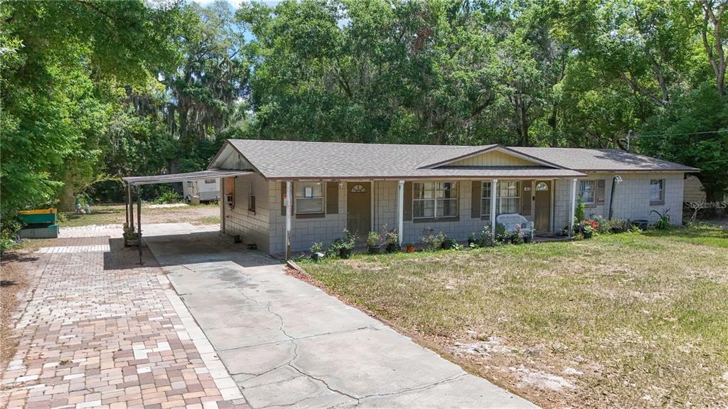 A single-story house with a concrete block exterior, a carport, and a paved driveway — 1400 N SIMPSON STREET, MOUNT DORA, FL