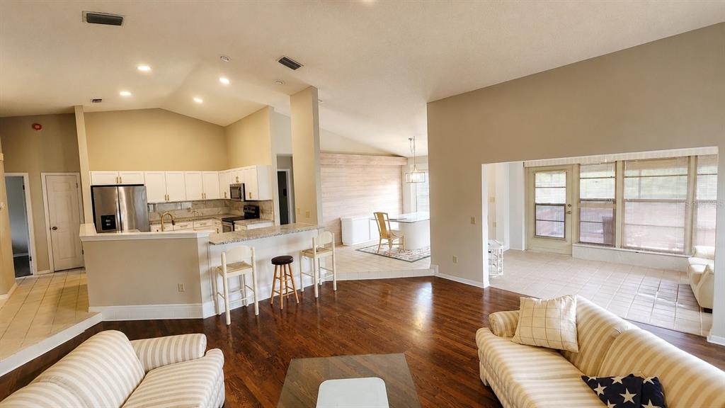 A living room features a stone fireplace, two sofas, a rug, and hardwood floors — 13036 TOPFLITE COURT, HUDSON, FL