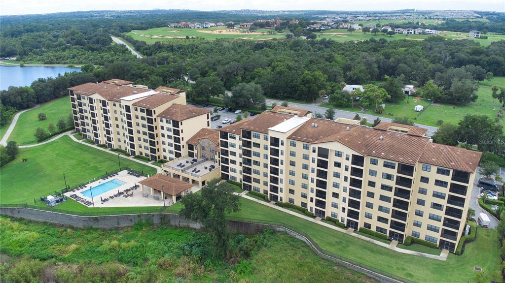 An aerial view shows two large multi-story apartment buildings with a pool and patio area — 16300 COUNTY ROAD 455 UNIT 307, MONTVERDE, FL