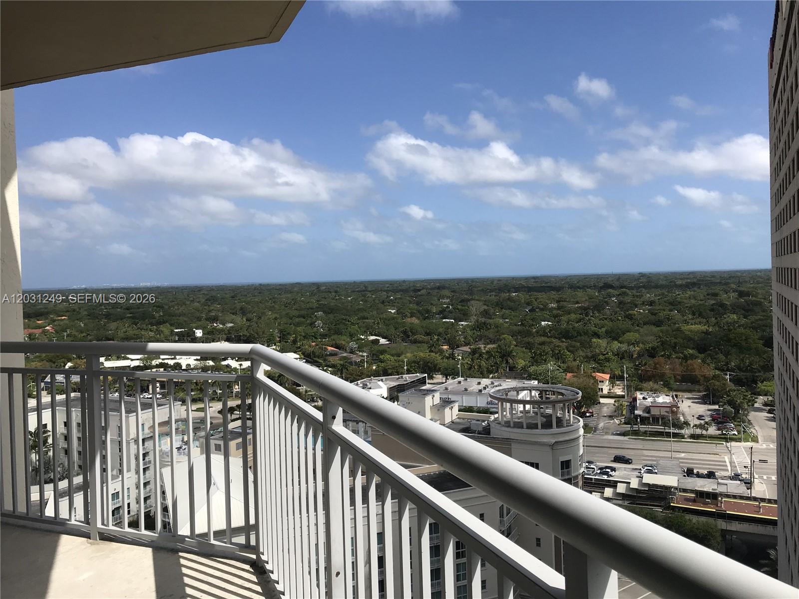 A high-rise balcony overlooks a suburban landscape with trees, buildings, and a distant horizon — 9055 SW 73rd Ct # 1604, Miami FL 33156, MIAMI, FL