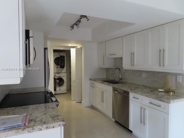 A kitchen features white cabinets, granite countertops, stainless steel appliances, and a stacked laundry unit — 11543 SW 109th Rd # 24B, Miami FL 33176, MIAMI, FL