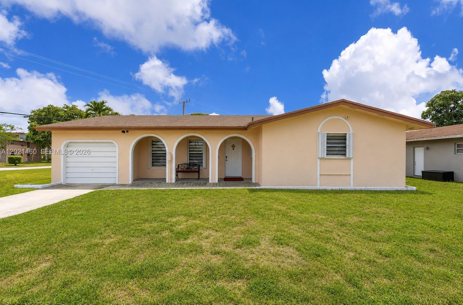 A single-story peach-colored house features an attached garage, three arched entryways, and a lawn — 850 NW 79th Ave, Margate FL 33063, MARGATE, FL