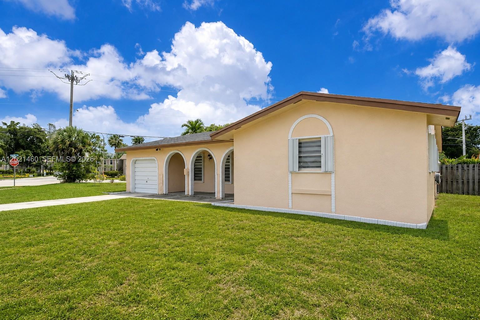 A single-story peach-colored house features arched entryways, a small garage, and a front lawn — 850 NW 79th Ave, Margate FL 33063, MARGATE, FL