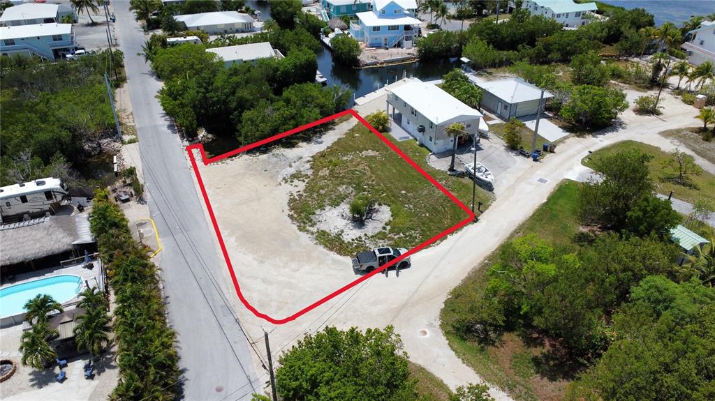 An aerial view shows a vacant, rectangular lot outlined in red next to a canal — 2080 CORAL WAY, BIG PINE KEY, FL