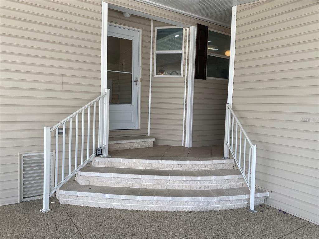 A set of three curved brick steps leads to a white door and entryway — 724 BLACKBURN BOULEVARD, NORTH PORT, FL