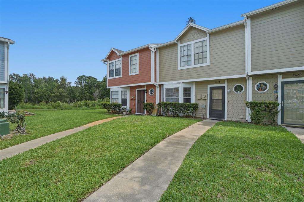 A row of two-story townhomes with beige and red siding and concrete walkways — 2025 WATERLEAF STREET, ORLANDO, FL