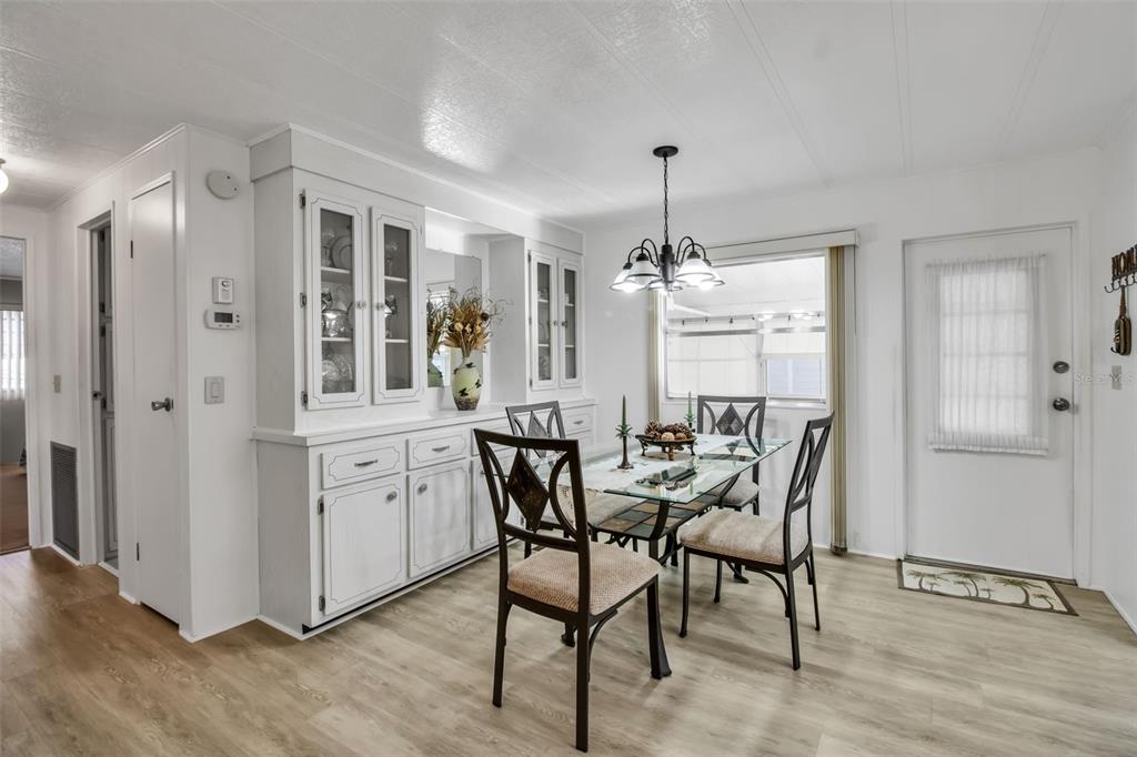 A dining room features a glass-topped table, four chairs, and a white built-in hutch — 5619 BAYSHORE ROAD UNIT 160, PALMETTO, FL