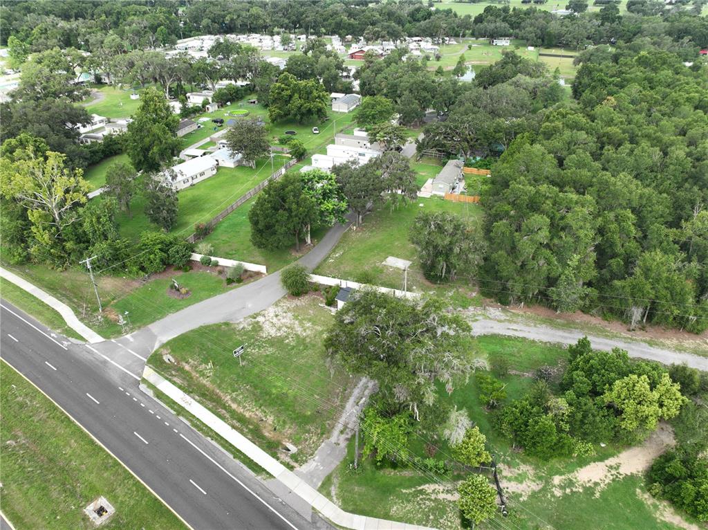 An aerial view shows a paved road leading to a property with trees and buildings — 37351 CARRINGER ROAD, DADE CITY, FL