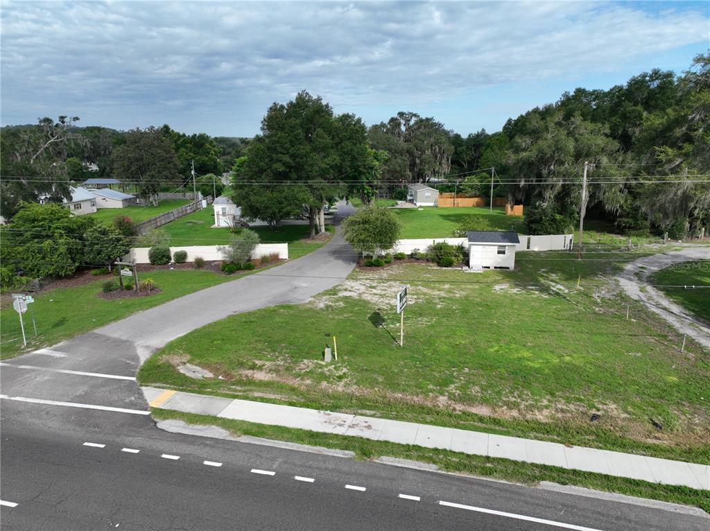 An aerial view shows a grassy vacant lot adjacent to a paved road and driveway — 37351 CARRINGER ROAD, DADE CITY, FL