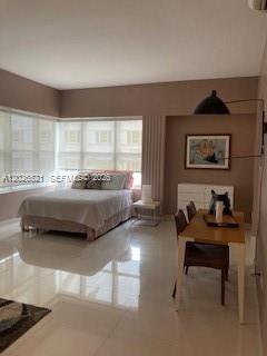 A bedroom with a bed, a dining table, and a white dresser against a wall — 2421 Lake Pancoast Dr # 3B, Miami Beach FL 33140, MIAMI BEACH, FL