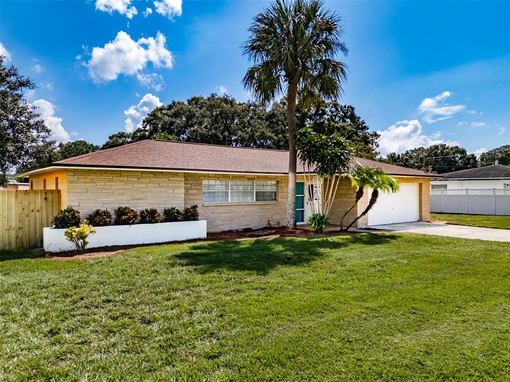 A single-story house with stone siding, a white planter, and a palm tree in front — 5004 S HESPERIDES STREET, TAMPA, FL