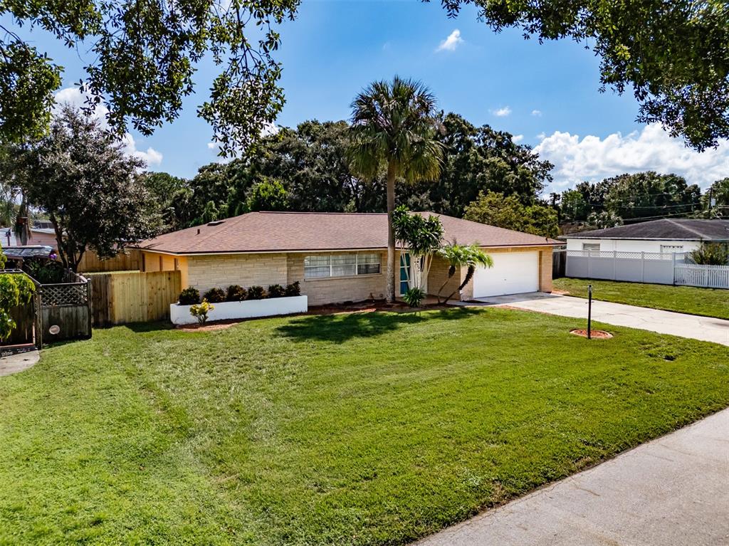 A single-story house with a stone facade, a two-car garage, and a large front lawn — 5004 S HESPERIDES STREET, TAMPA, FL