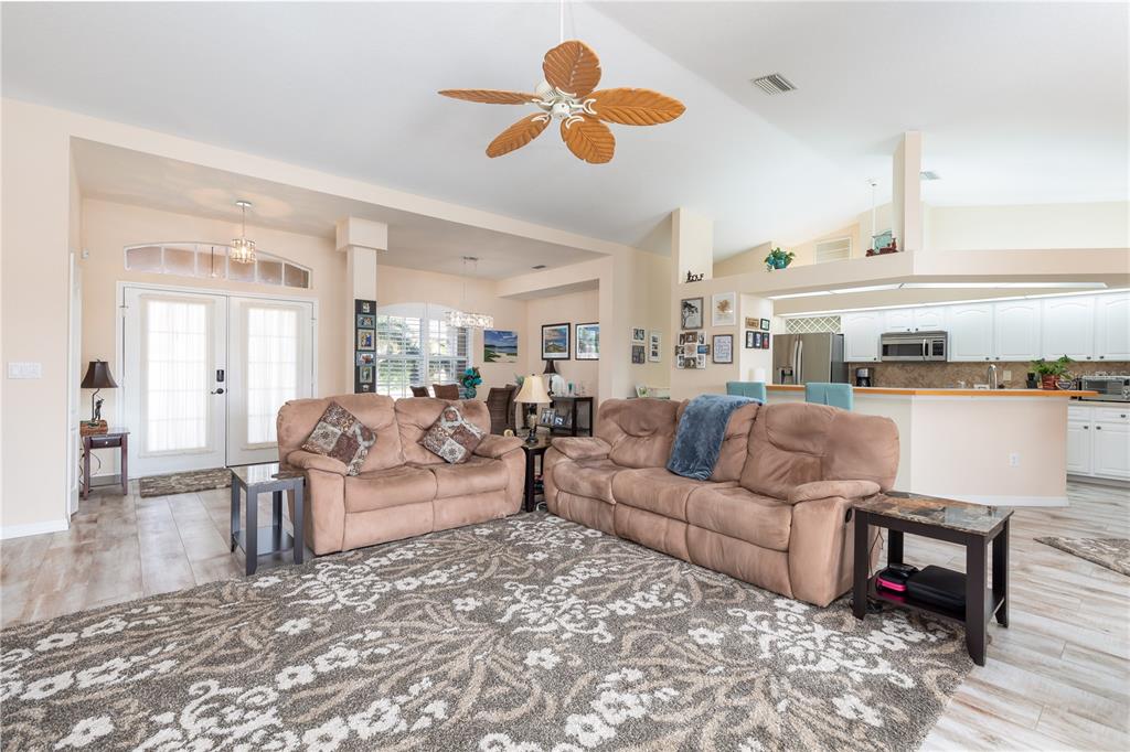 A living room with light-colored tile floors, two brown sofas, and a ceiling fan — 4077 LA COSTA ISLAND COURT, PUNTA GORDA, FL