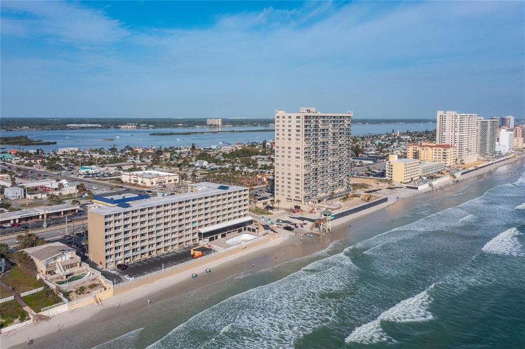 An aerial view of a beachfront hotel and high-rise condominiums along a sandy coastline — 3501 S ATLANTIC AVENUE UNIT 5200, DAYTONA BEACH, FL