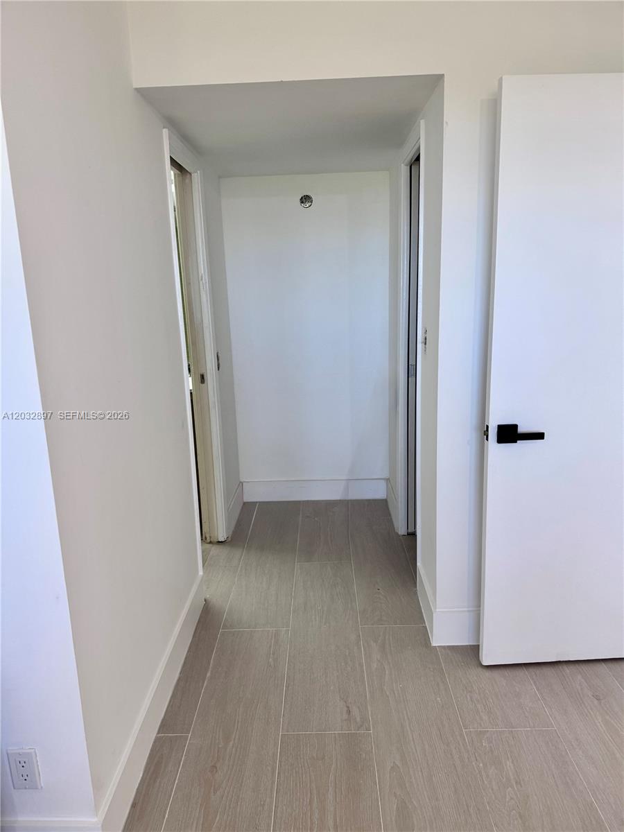 A hallway with light-colored tile flooring leads to a small alcove between two doorways — 575 Oaks Ln # 1008, Pompano Beach FL 33069, POMPANO BEACH, FL