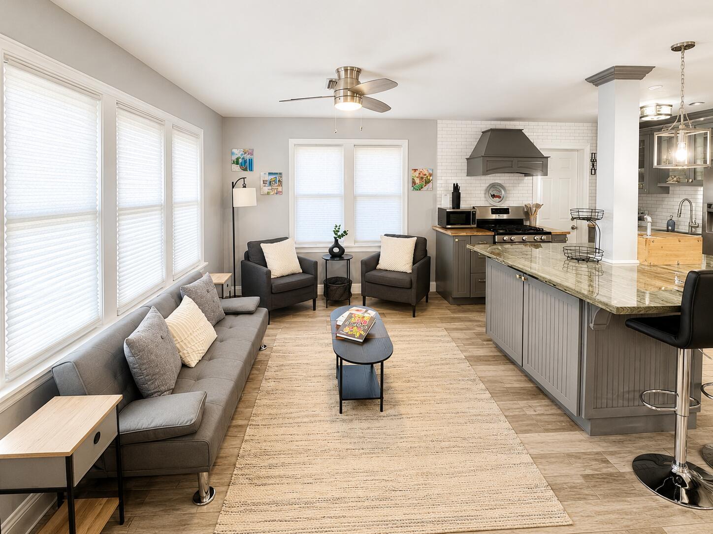A living room and kitchen area with gray furniture, a kitchen island, and wood flooring — 322 S L Street, FL 33460, FL
