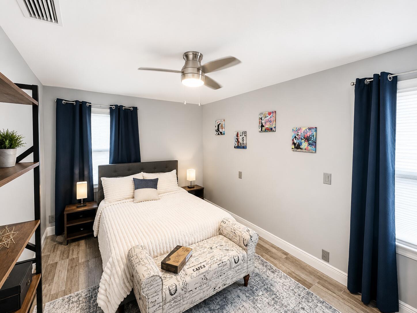 A bedroom features a bed with a white comforter, a patterned bench, and navy curtains — 322 S L Street, FL 33460, FL