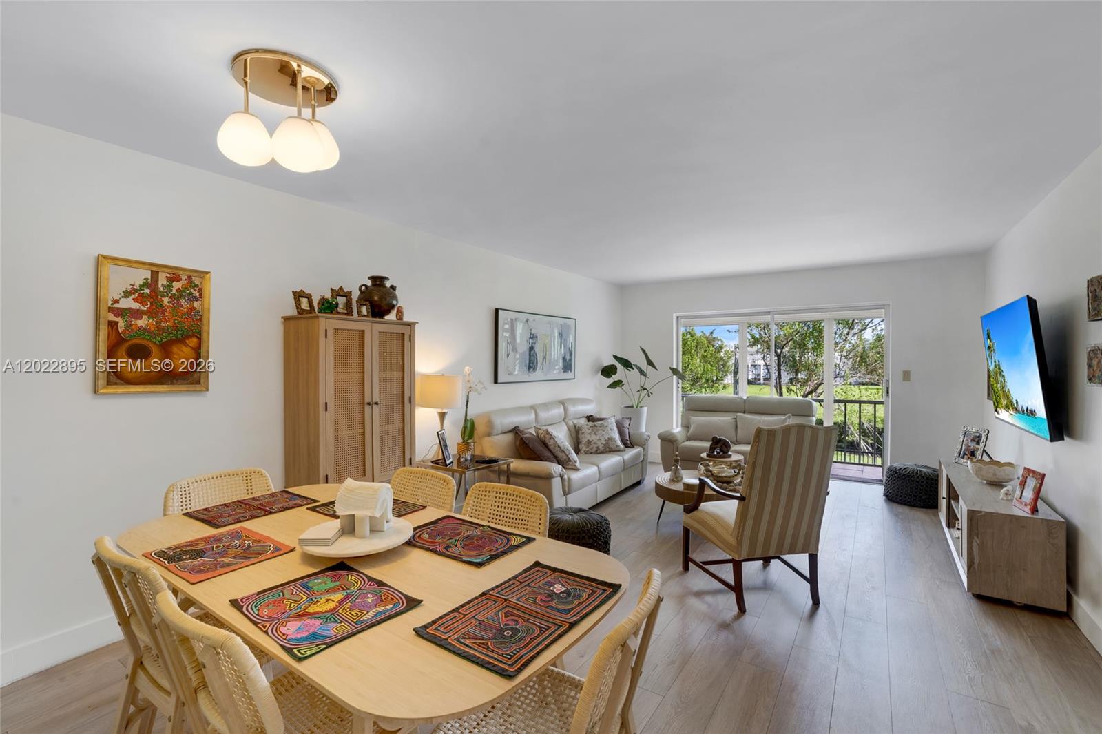 A living and dining area features light wood flooring, neutral furniture, and a balcony view — 950 Hillcrest Dr # 212, Hollywood FL 33021, HOLLYWOOD, FL