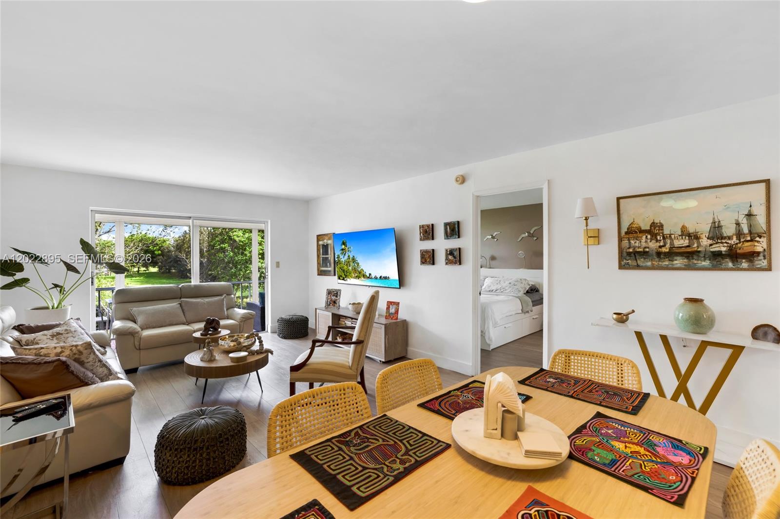 A living and dining area features light wood flooring, a television, and a balcony view — 950 Hillcrest Dr # 212, Hollywood FL 33021, HOLLYWOOD, FL