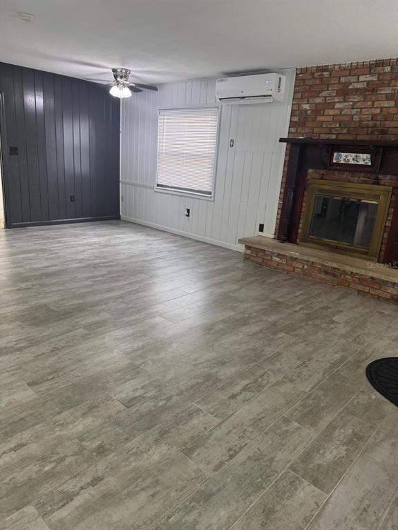 An open-concept living area features light wood-look tile flooring, recessed lighting, and a white kitchen — 1905 ROSLYN AVENUE, BRADENTON, FL