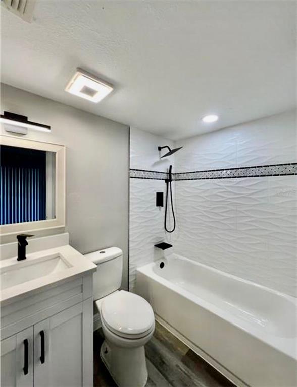 A modern bathroom featuring a white vanity, toilet, and a tiled shower-tub combination — 7108 WATERSIDE DRIVE UNIT 103, TAMPA, FL