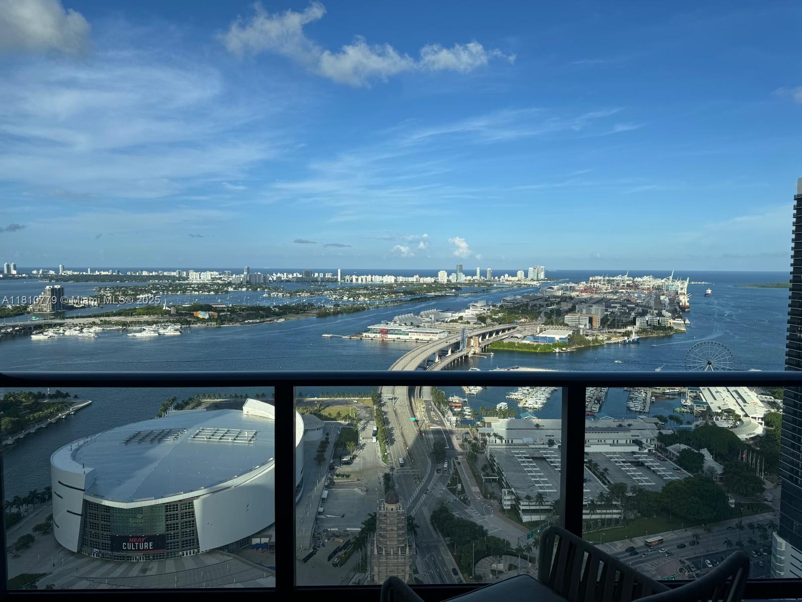 A high-angle view from a balcony overlooking the Kaseya Center, a bridge, and Miami harbor — 159 NE 6TH ST # 4215, Miami FL 33132, MIAMI, FL