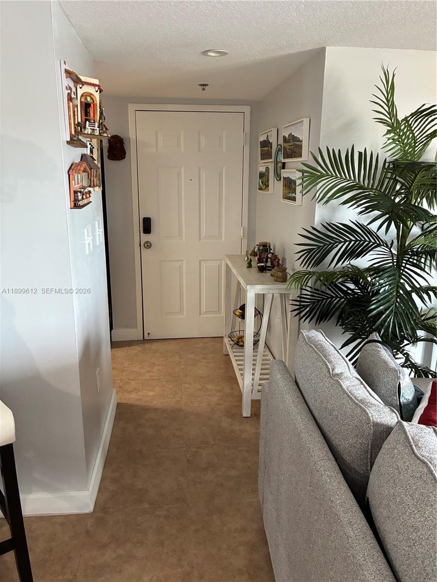 An entryway features a white door, a console table, a potted plant, and wall decor — 1650 Coral Way # 808, Miami FL 33145, MIAMI, FL