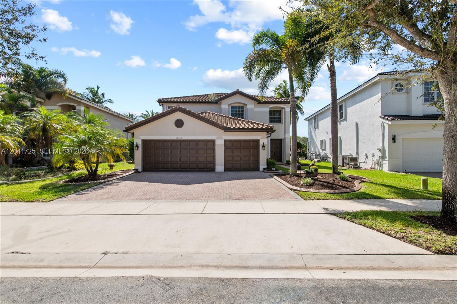 A two-story suburban house with a brown tile roof, three-car garage, and paved driveway — 16230 SW 21st St, Miramar FL 33027, MIRAMAR, FL