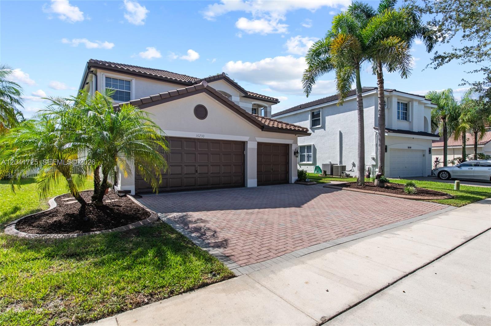 A two-story house with a brown tile roof, a brick driveway, and a three-car garage — 16230 SW 21st St, Miramar FL 33027, MIRAMAR, FL