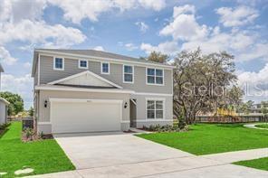 A two-story house with light gray siding, a two-car garage, and a green lawn — 5614 OAK KNOLL DRIVE, ST CLOUD, FL