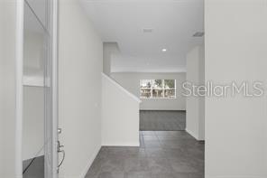 An interior view of a home entryway with tile flooring and a staircase — 5614 OAK KNOLL DRIVE, ST CLOUD, FL