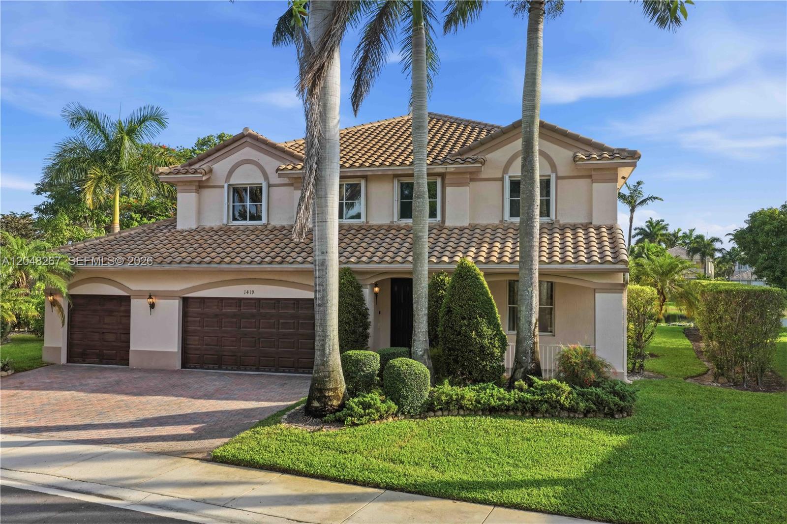 A two-story suburban house with a tile roof, three-car garage, and palm trees — 1419 Crossbill Ct # 1419, Weston FL 33327, WESTON, FL