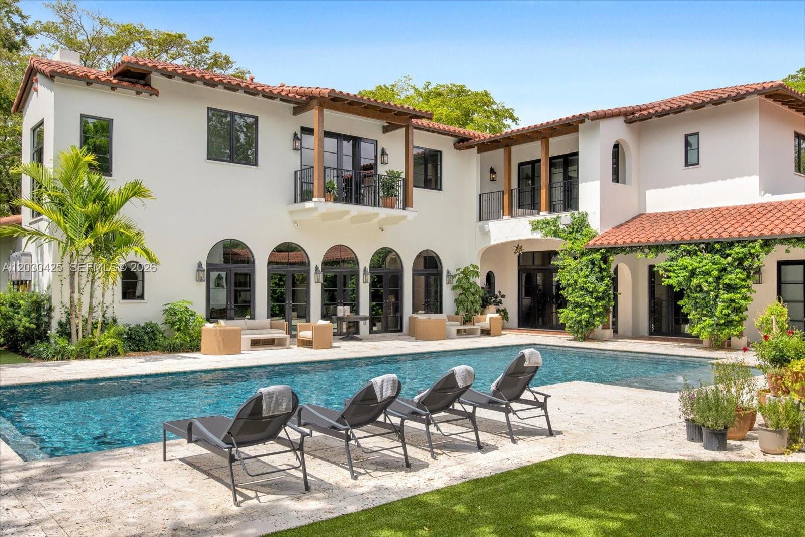A two-story Mediterranean-style house with a swimming pool and patio lounge chairs — 545 San Antonio Ave, Coral Gables FL 33146, CORAL GABLES, FL