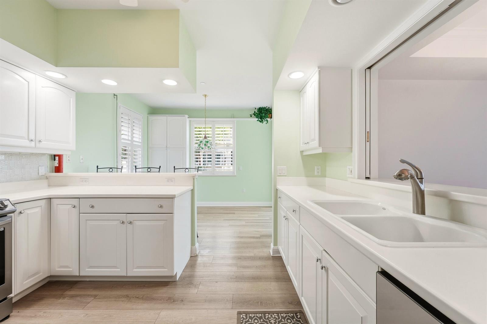 A bright kitchen features white cabinets, light countertops, and light green walls — 4775 S Harbor Drive # 201, Vero Beach FL 32967, VERO BEACH, FL