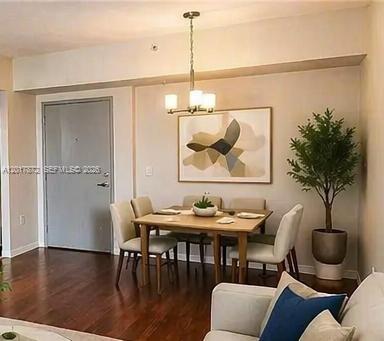A dining area with a wooden table, four chairs, a chandelier, and a potted plant — 36 NW 6th Ave # 805, Miami FL 33128, MIAMI, FL
