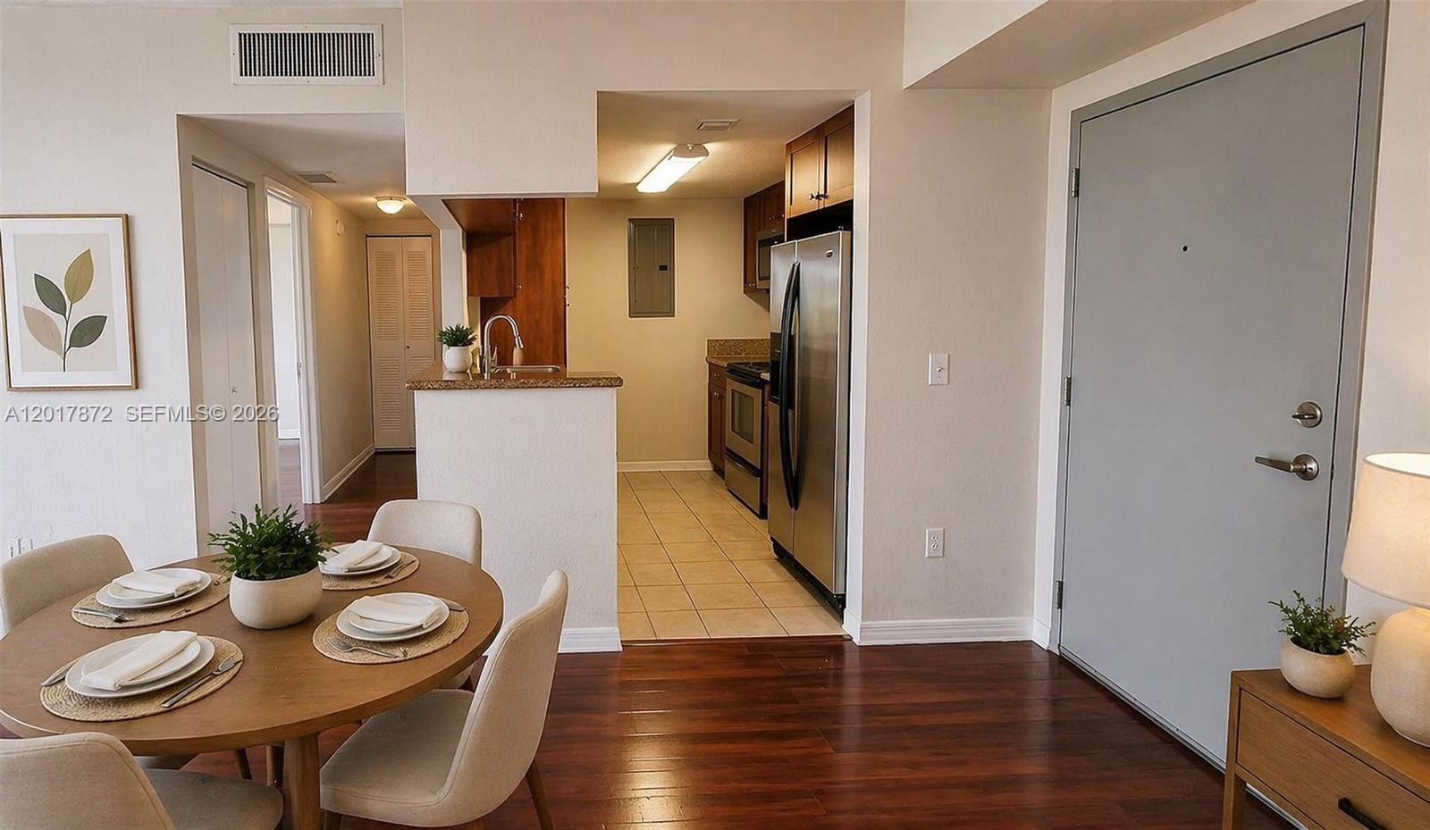 A dining area with a round table opens into a kitchen with stainless steel appliances — 36 NW 6th Ave # 805, Miami FL 33128, MIAMI, FL