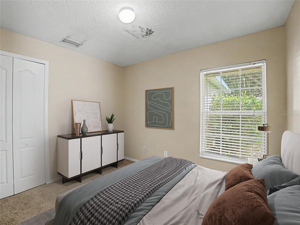 A bedroom features a bed, a white cabinet, a window with blinds, and a ceiling light — 5828 WRENWATER DRIVE, LITHIA, FL