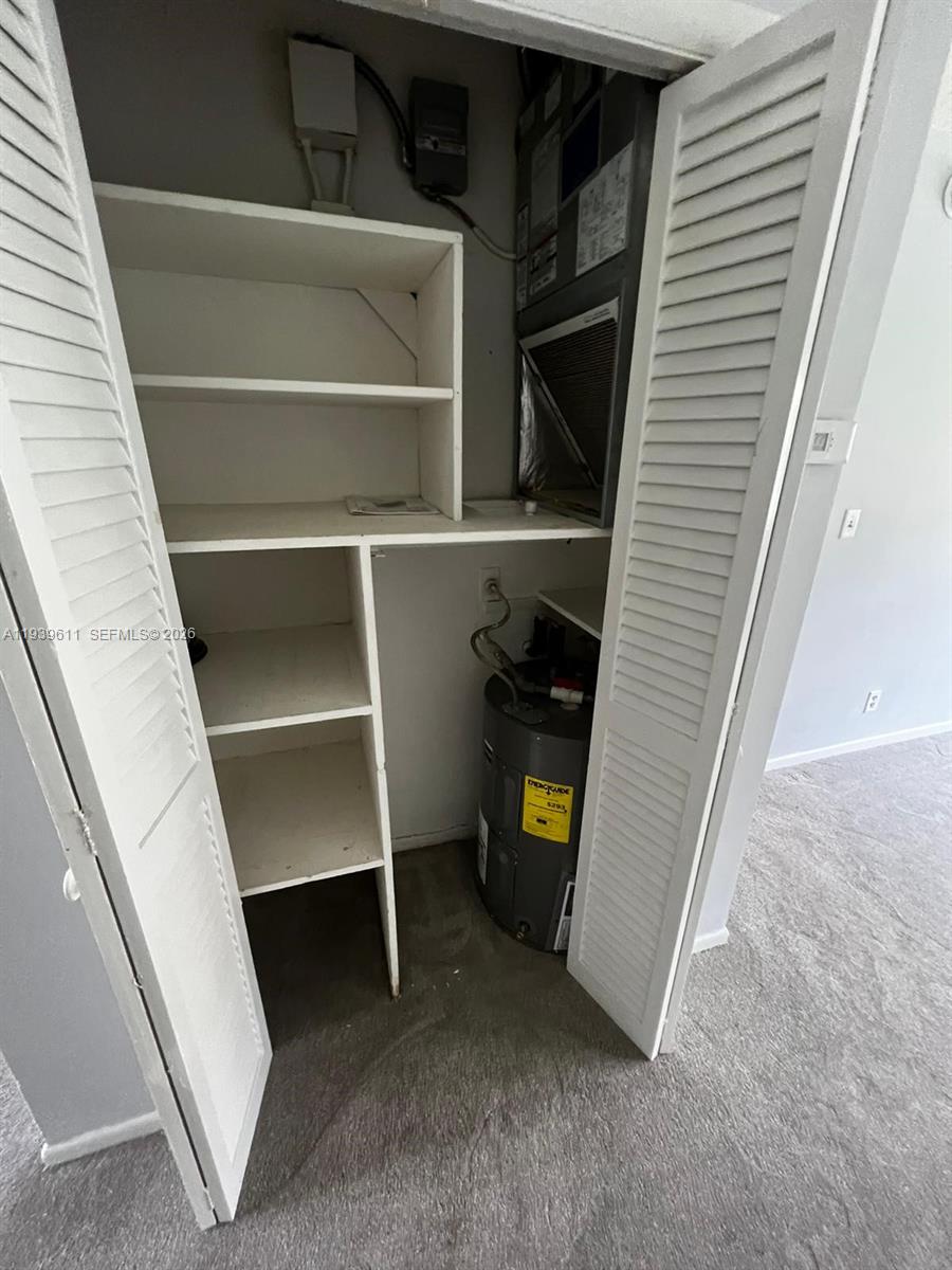 A closet contains built-in shelving, a water heater, and an HVAC air handler unit — 2701 NE 1st St # 203, Pompano Beach FL 33062, POMPANO BEACH, FL