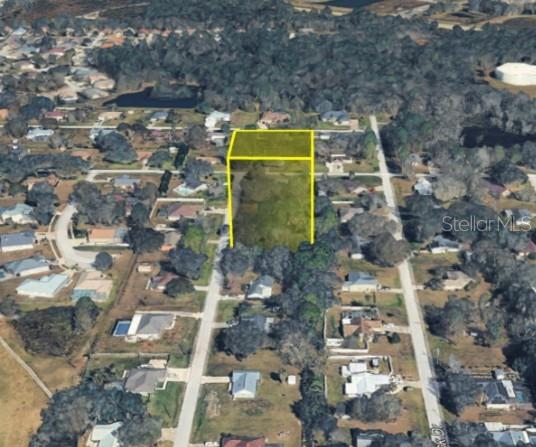 An aerial view shows a vacant, rectangular residential lot highlighted by a yellow outline — 5728 ELAINE DRIVE, ZEPHYRHILLS, FL
