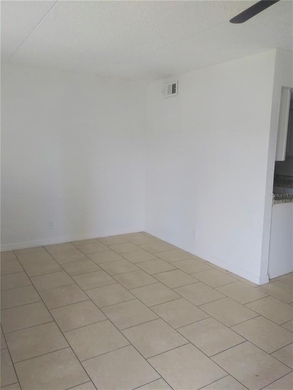 An empty room with white walls and light-colored square floor tiles — 302 S SPRING GARDEN AVENUE UNIT B09, DELAND, FL